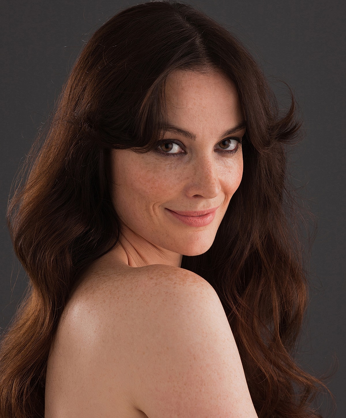 Woman with long, wavy hair and freckles.