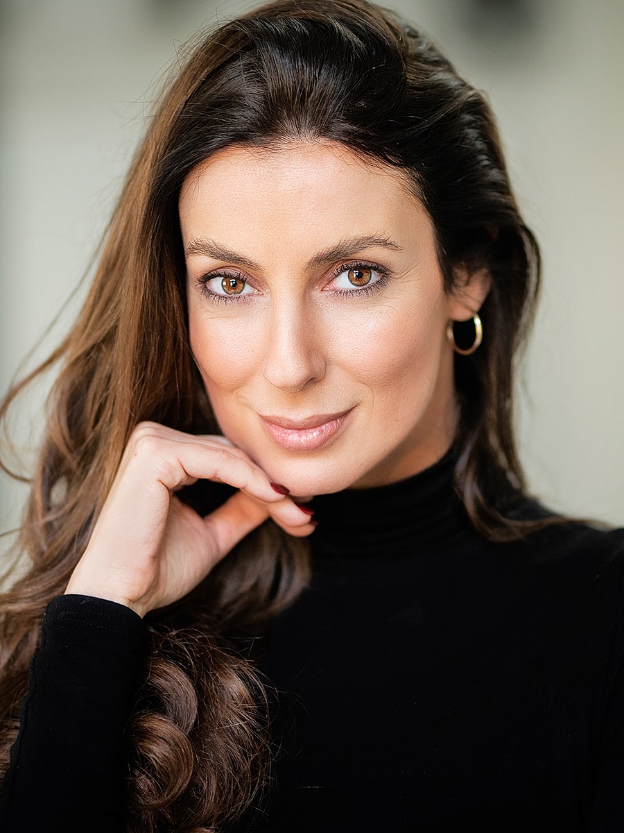 Smiling woman with long dark hair and black shirt.