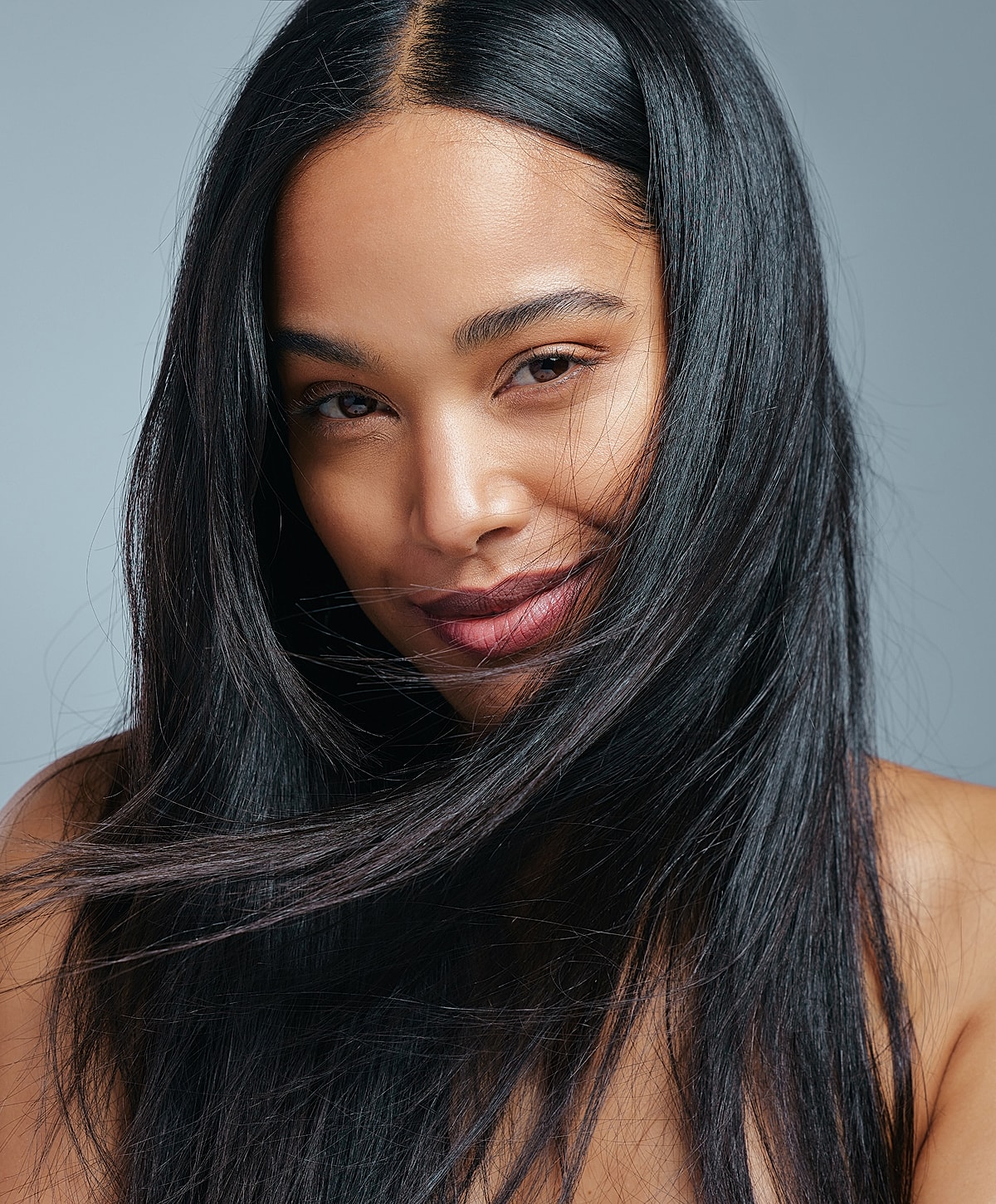 Woman with long hair smiling confidently.