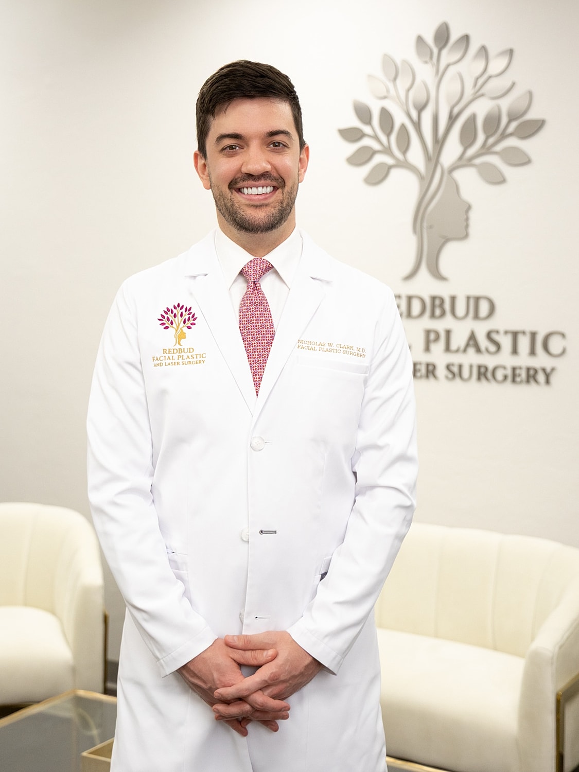 Smiling doctor in white coat, office background.