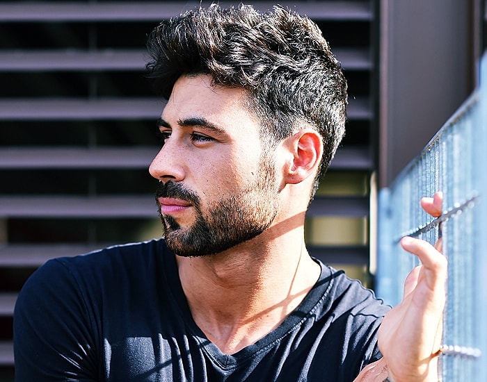 Man with beard looking thoughtfully to the side.