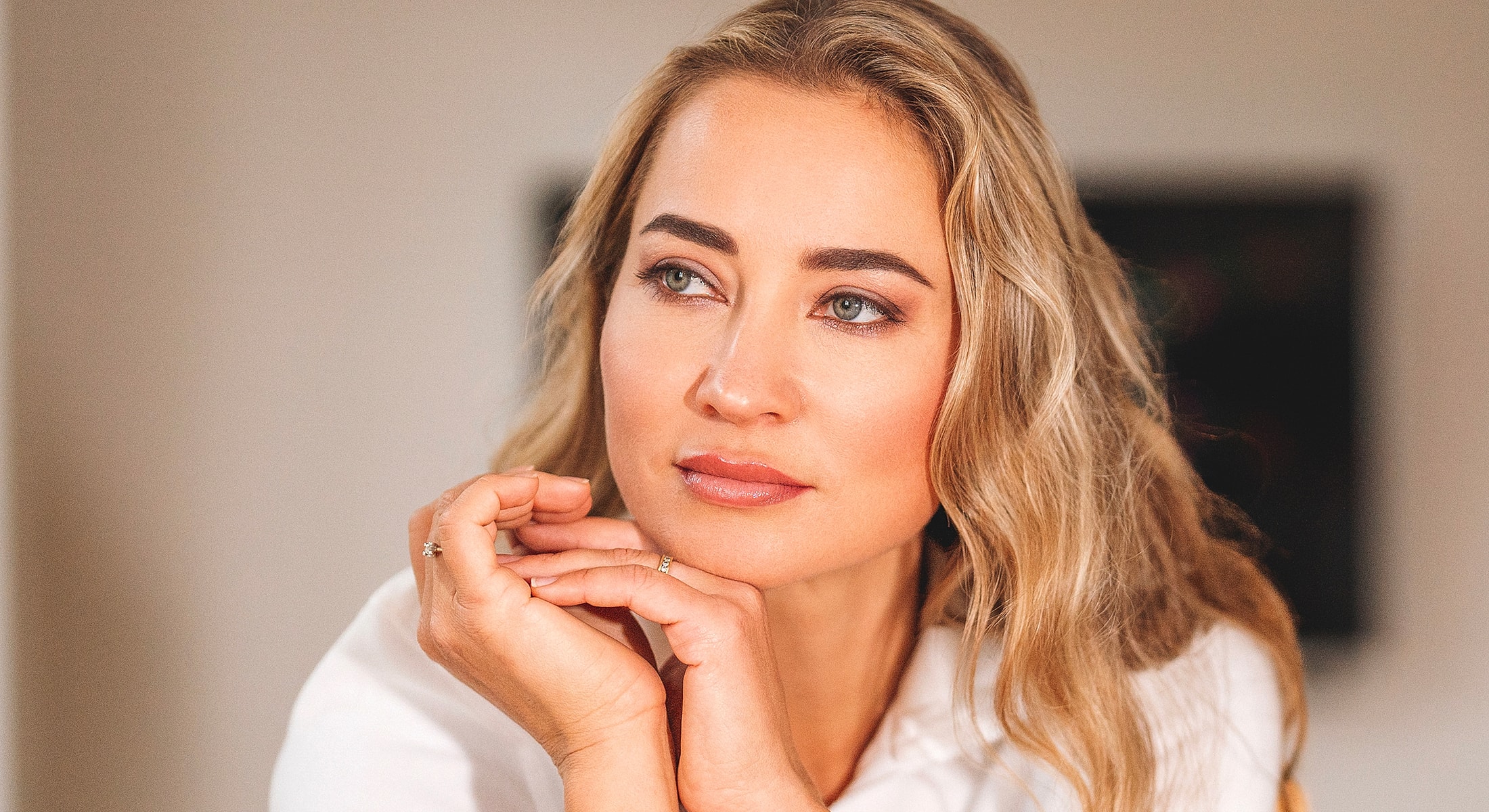 Thoughtful woman with long, wavy hair.