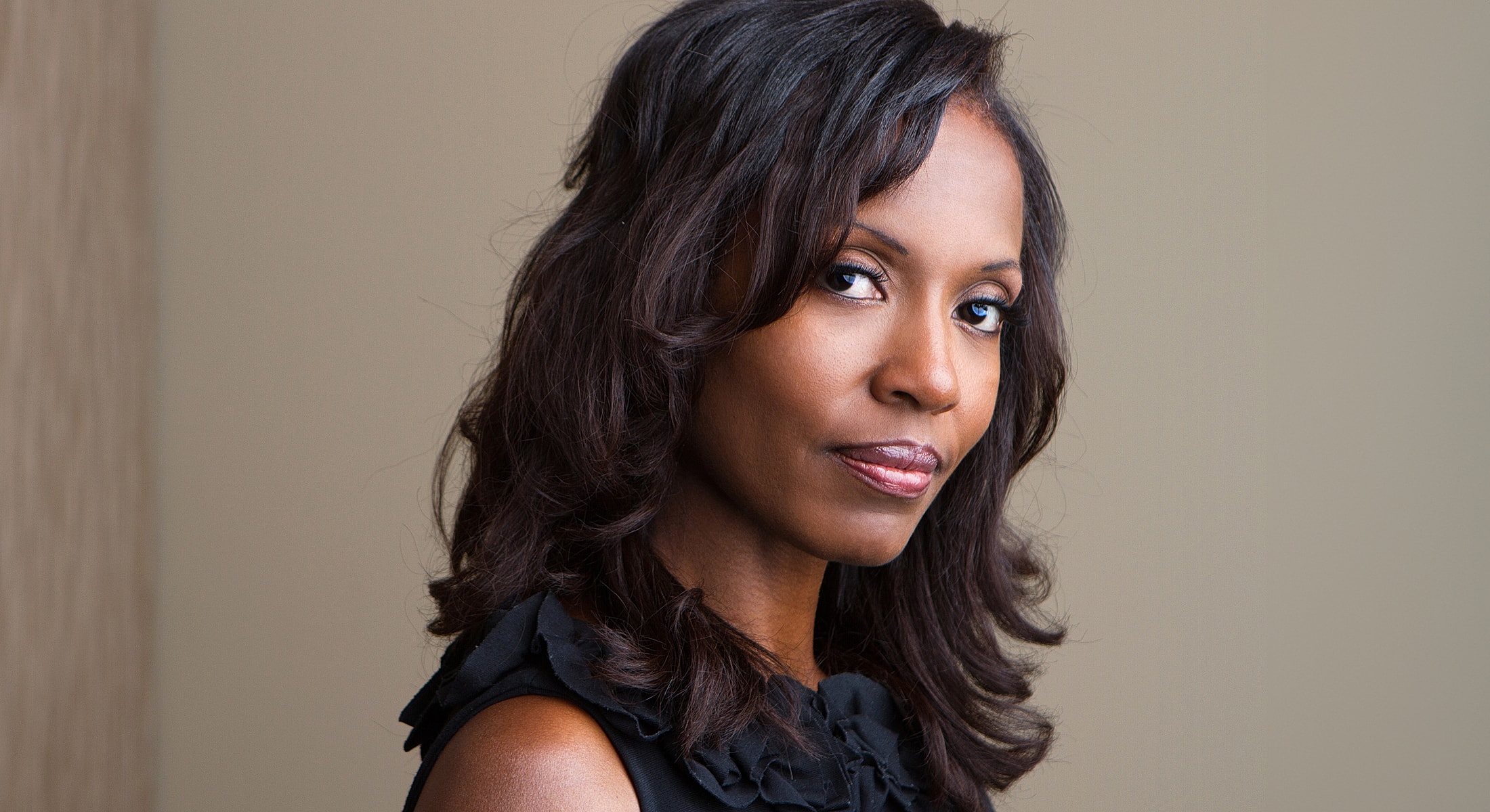 Woman with long hair posing confidently.