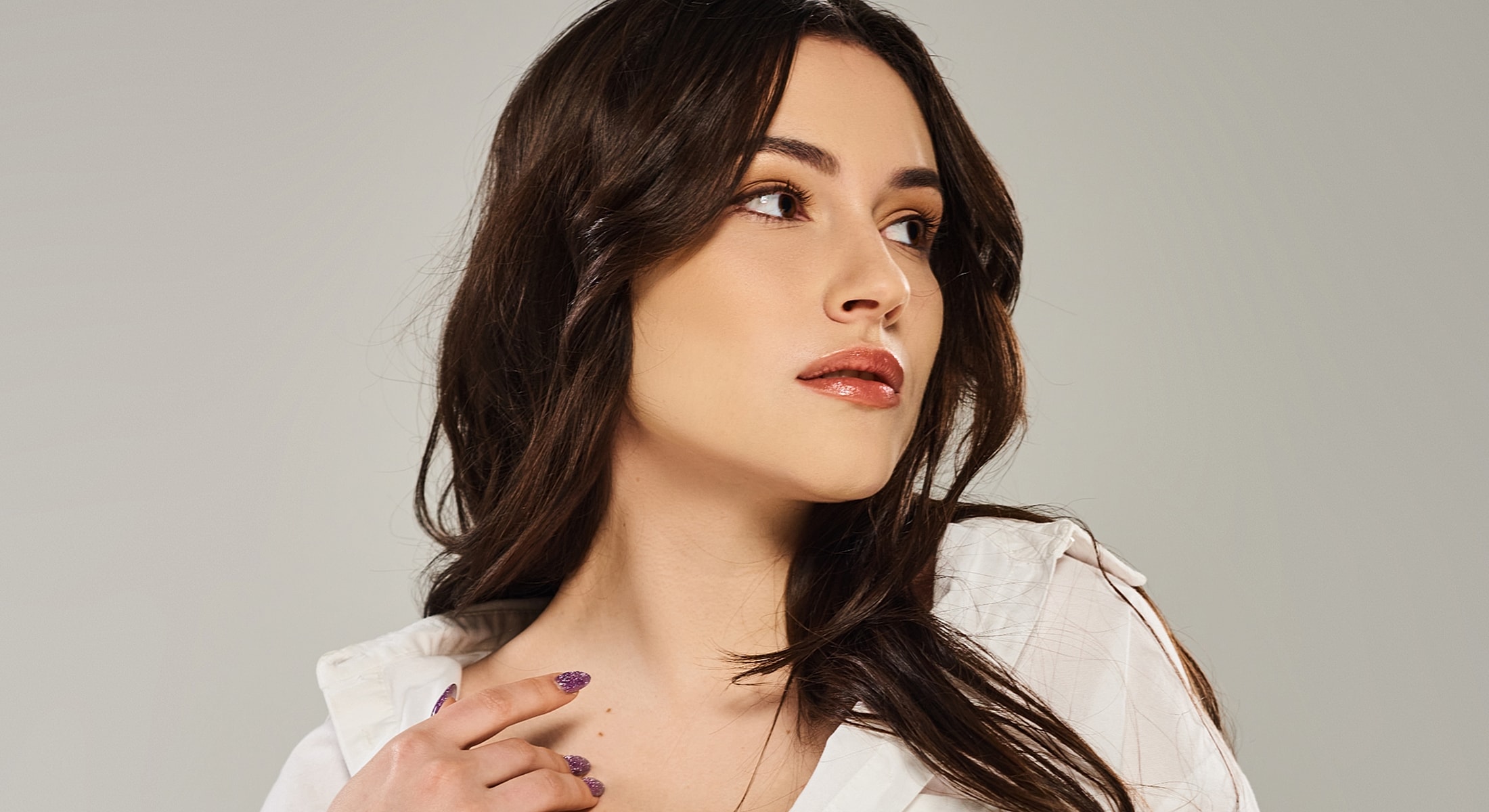 Woman with long hair wearing white shirt.